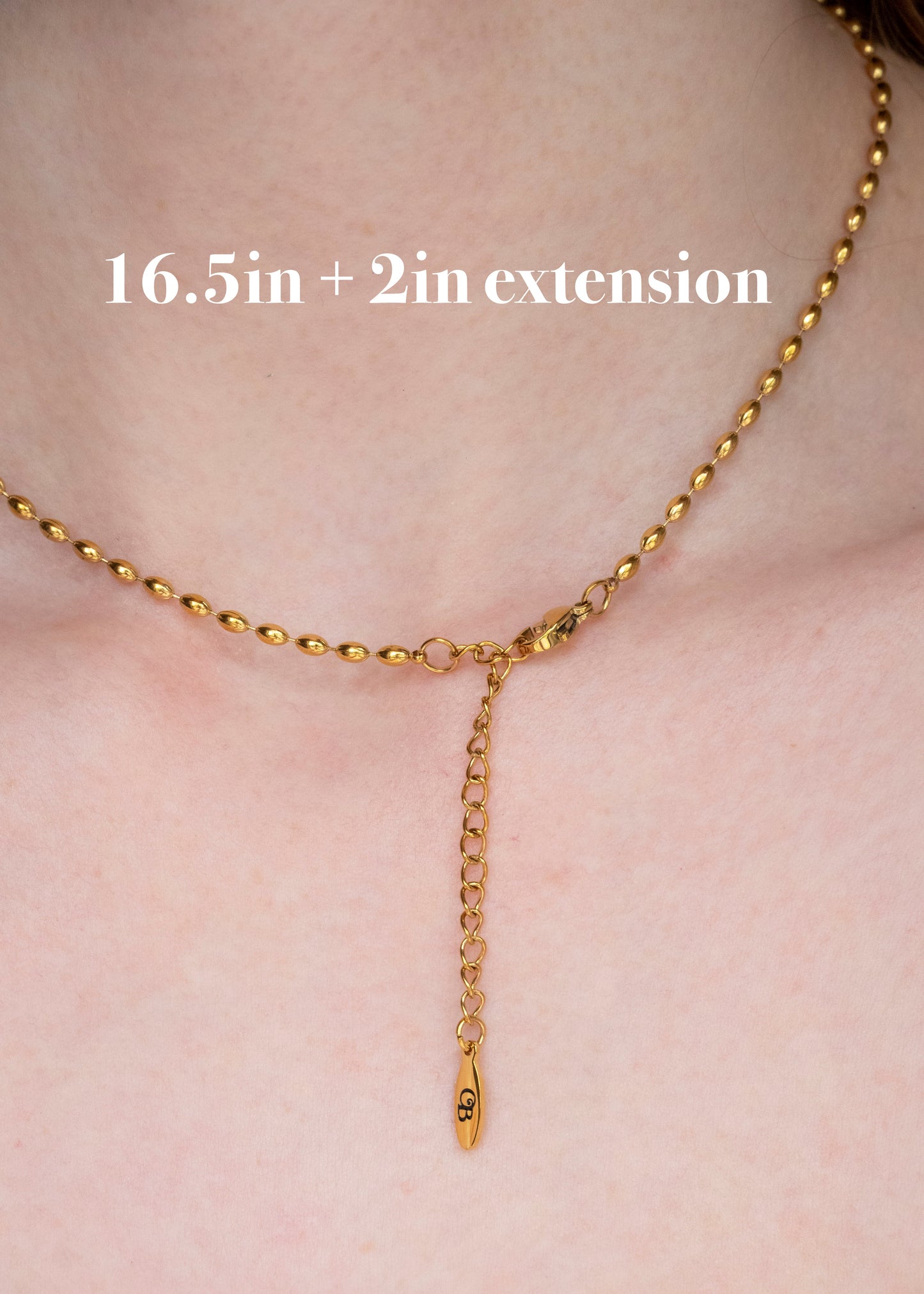 Gold necklace with extension on a person's neck, labeled '16.5in + 2in extension'.