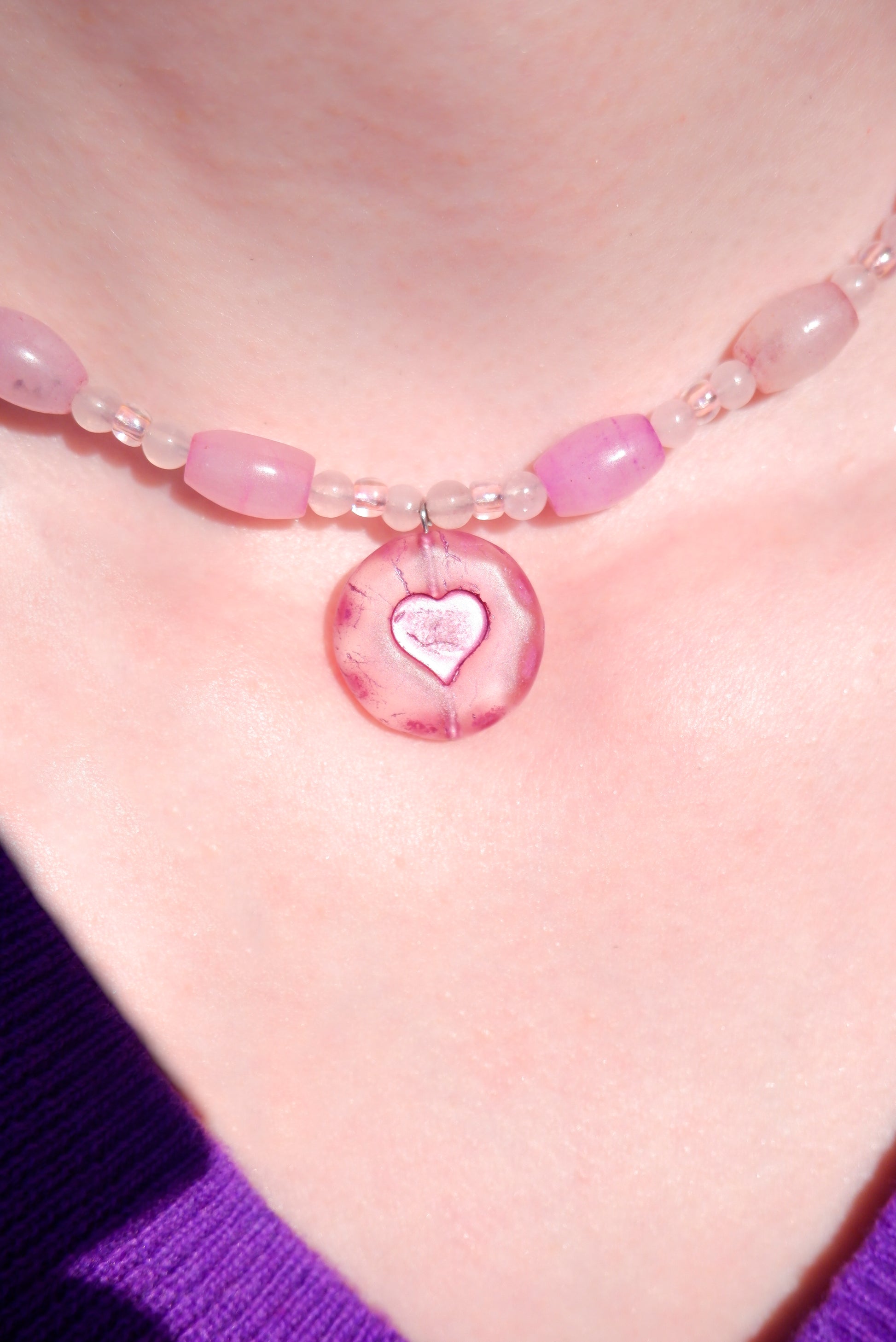 A necklace with a pink heart pendant and rose quartz beads