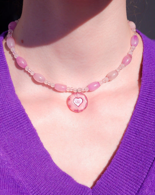 A necklace with a pink heart pendant and rose quartz beads