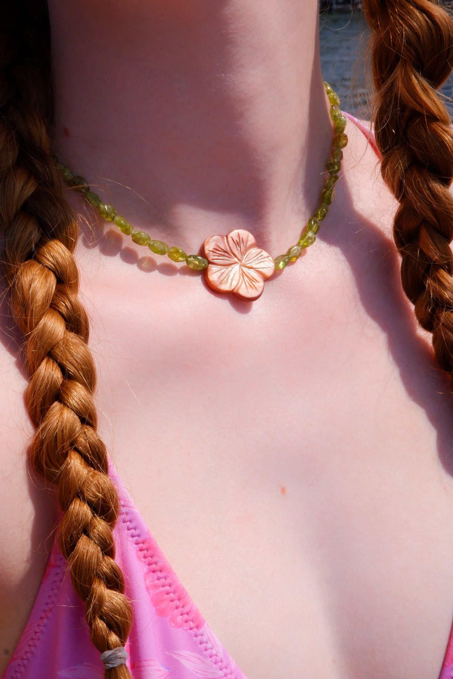 brown mother-of-pearl shell flower necklace on a strand of green peridot beads