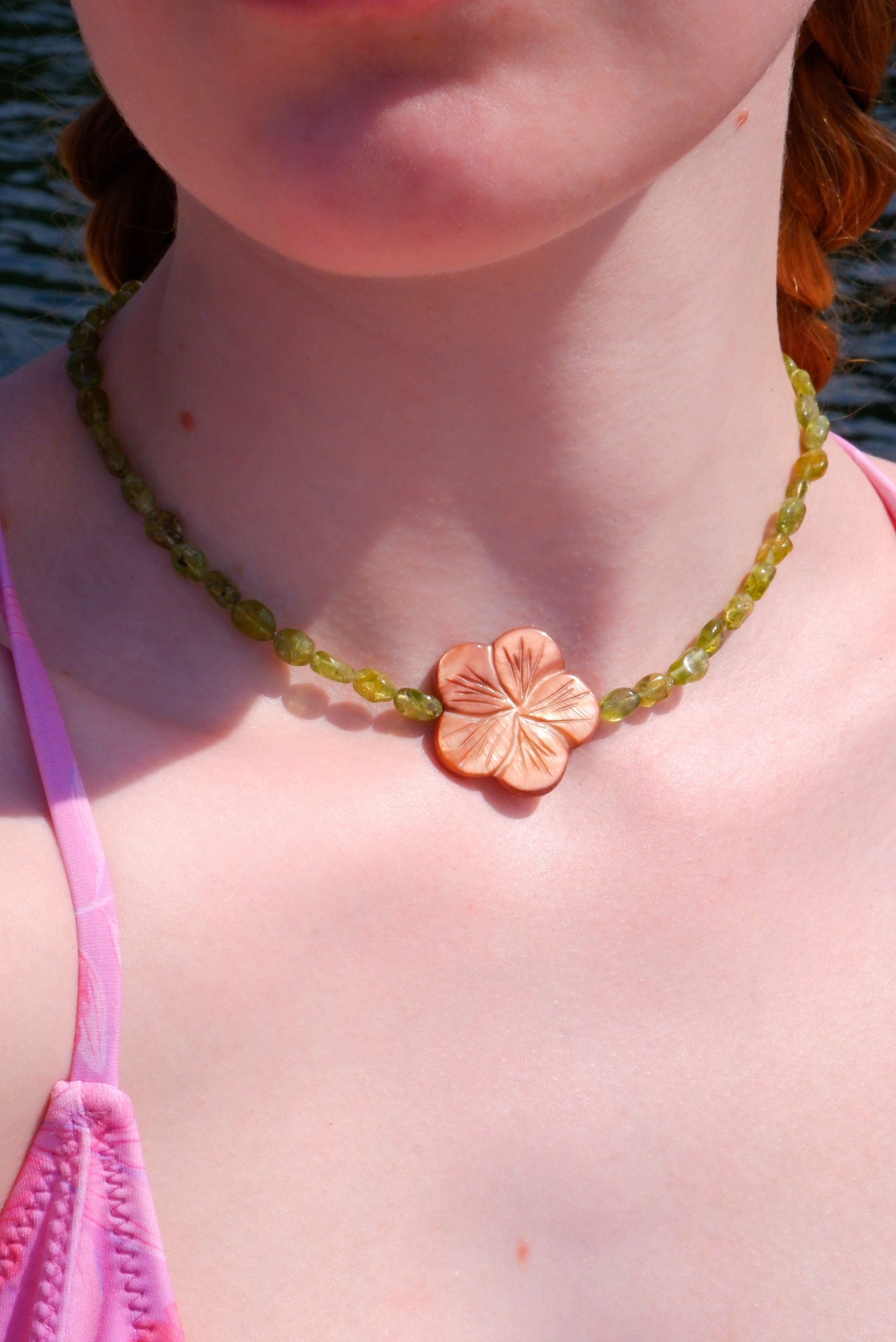 brown mother-of-pearl shell flower necklace on a strand of green peridot beads