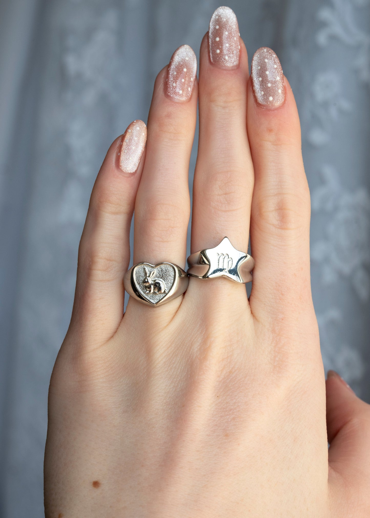 heart shaped ring with a bunny inside and a star shaped ring with star sign engraving