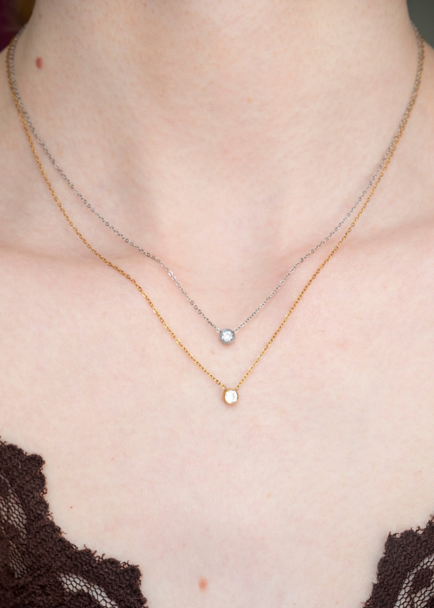 Close-up of a necklace with a small pendant on a person's neck
