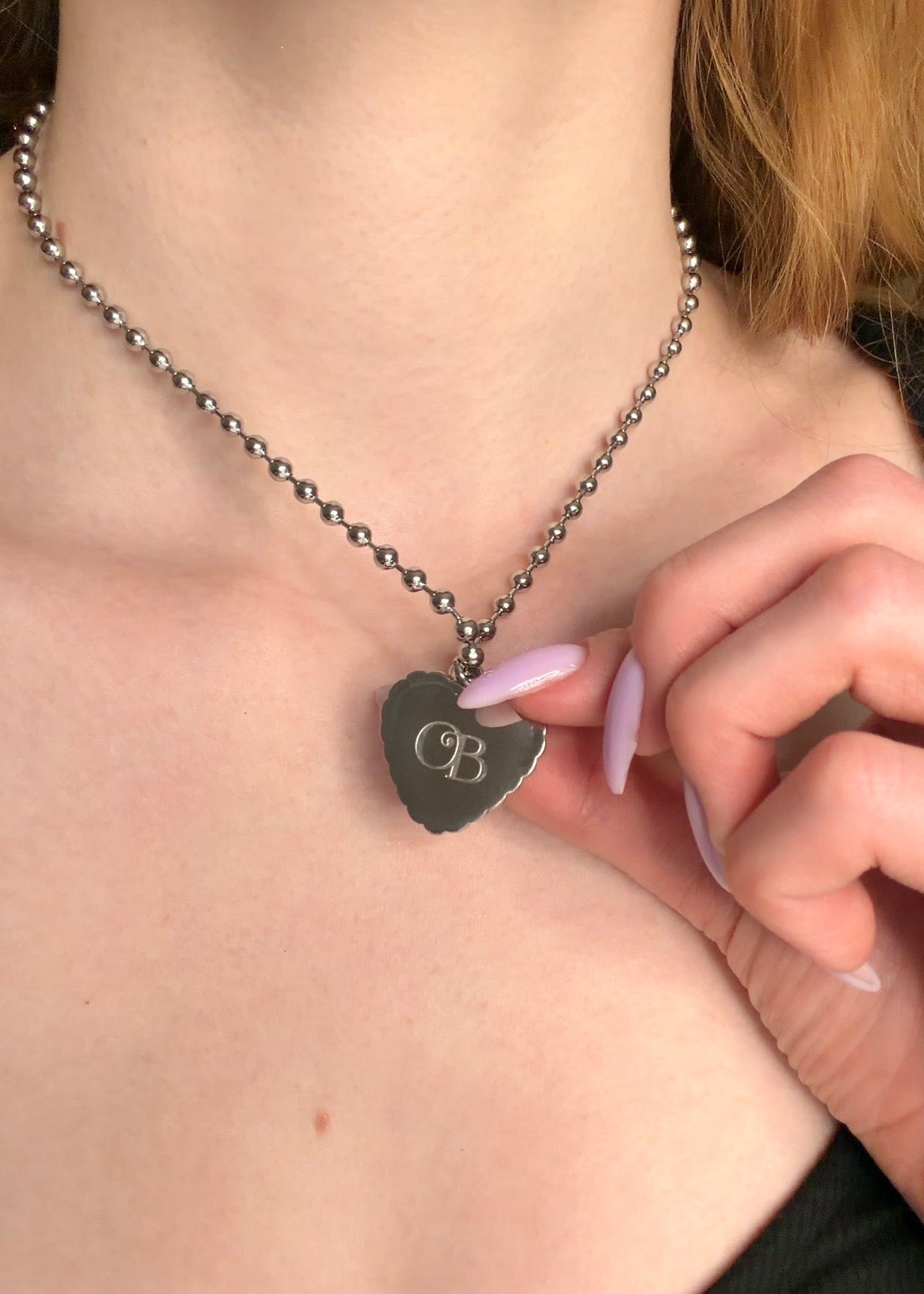 Necklace with a heart-shaped pendant worn by a person